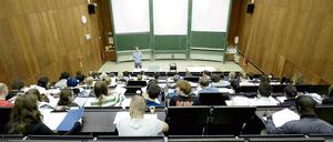 Ein Dozent steht in einem Hörsaal vor Studierenden.