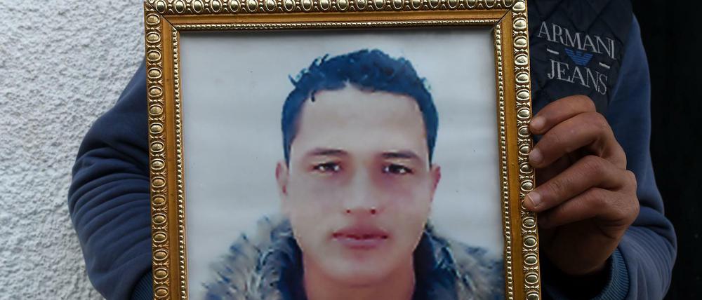Der Bruder des mutmaßlichen Terroristen Anis Amri zeigte am Freitag in Tunesien ein Porträt des Getöteten.