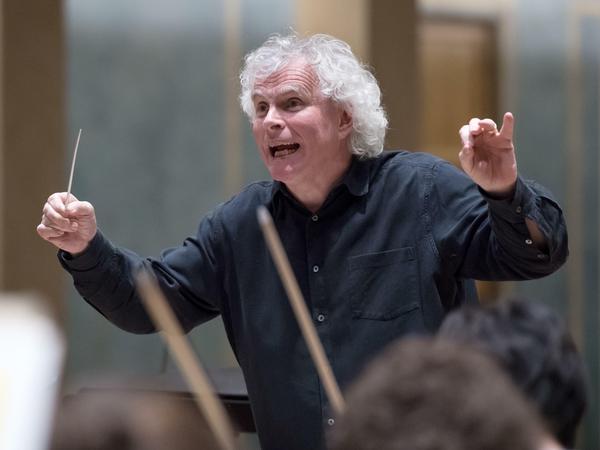 Sir Simon Rattle dirigiert.