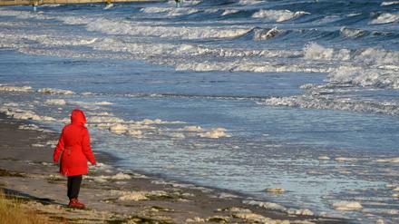 Nach der Sturmflut an der Ostsee. Eine Frau spaziert am Strand bei Scharbeutz (Schleswig-Holstein). Tief "Axel" zieht weiter.