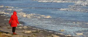 Nach der Sturmflut an der Ostsee. Eine Frau spaziert am Strand bei Scharbeutz (Schleswig-Holstein). Tief "Axel" zieht weiter.