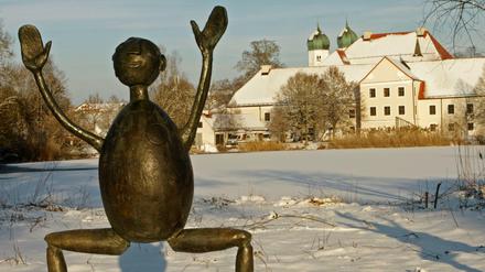 Eine Skulptur steht vor der Kulisse des Klosters Seeon