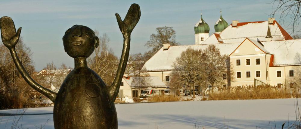 Eine Skulptur steht vor der Kulisse des Klosters Seeon