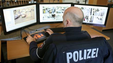 Ein Polizist überwacht in Duisburg an Monitoren die übertragenen Bilder von Videokameras.