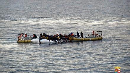 Rettung aus Seenot. Italienische Marinesoldaten helfen Flüchtlingen vor der Küste Siziliens.