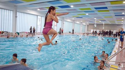 Ein Mädchen springt in das Becken der sanierten Schwimmhalle an der Thomas-Mann-Straße im Stadtteil Prenzlauer Berg. 