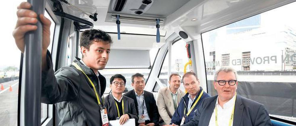 Rundfahrt auf dem Messegelände in Las Vegas. Navya-Manager Henri Coron (rechts im Bild) präsentiert seinen Gästen den autonomen Van.