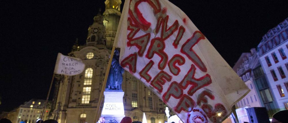 Teilnehmer des Friedensmarsch demonstrieren auf dem Neumarkt vor der Frauenkirche in Dresden.