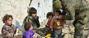 Das undatierte Handout des russischen Verteidigungsministeriums zeigt nach russischen Angaben einen Soldaten der russischen Armee, der in Aleppo Saft an Kinder verteilt.