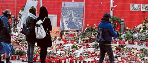 Menschen bleiben vor Kerzen und Blumen stehen, um der Opfer des Anschlags auf den Weihnachtsmarkt am Breitscheidplatz zu gedenken.