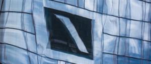 Die Zentrale der Deutschen Bank in Frankfurt am Main spiegelt sich in einer Glasfassade. Die Bank hat schwere Zeiten hinter sich.