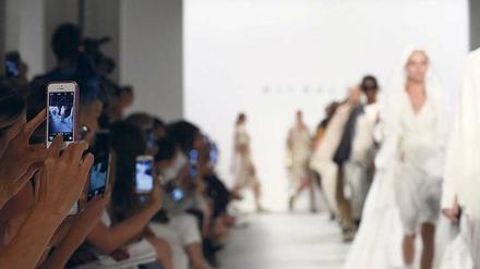 Foto, bitte! Statt einfach nur auf den Laufsteg starren die meisten Besucher bei Modenschauen nicht mehr auf die Models, sondern auf die Bildschirme ihrer Smartphones.