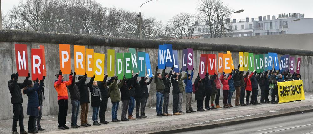 "Mr. President, Walls divide. Build bridges" - unter dem Motto demonstrieren am Freitag Aktivisten gegen den neuen US-Präsidenten.