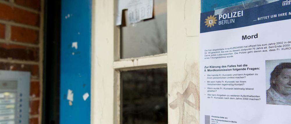 Ein Fahndungsplakat der Berliner Polizei an der Tür des Mehrfamilienhauses in der Naugarder Straße in Berlin. 