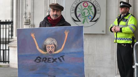 Der satirische Künstler Kaya Mar steht mit einem seiner Bilder vor dem Supreme Court in London. Vor dem Gericht geht es um die Frage, ob die britische Regierung den geplanten Austritt aus der Europäischen Union ohne Zustimmung des Parlaments einleiten darf.