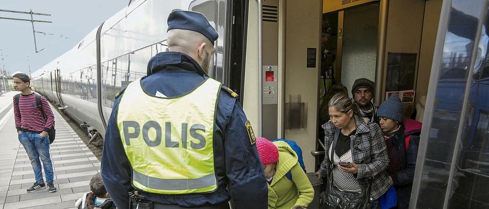 Ein schwedischer Polizist empfängt auf dem Bahnhof in Malmö Flüchtlinge. 