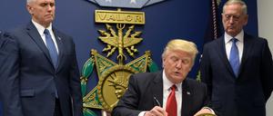 Mit Signatur und Siegel. Donald Trump unterschreibt neben Verteidigungsminister James Mattis (r) und Vizepräsident Mike Pence (l) im Pentagon sein Exekutiv-Dekret, mit dem der Zustrom von Flüchtlingen verringert werden soll. 
