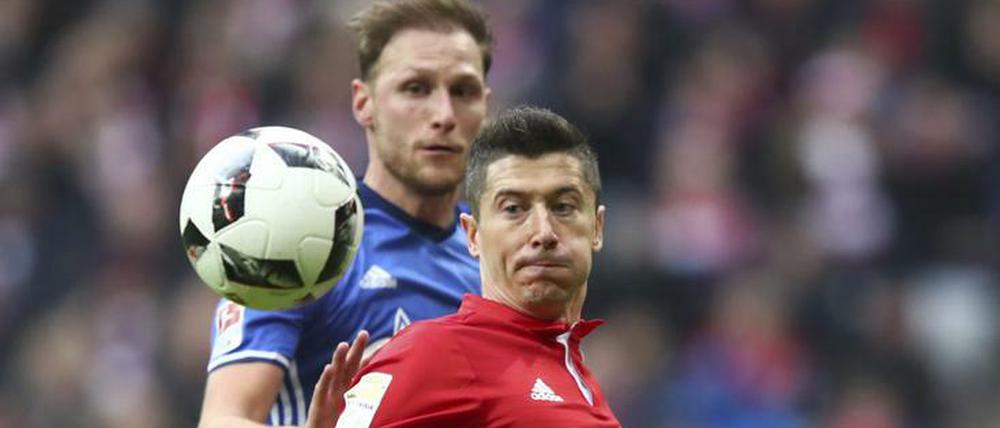 Blickfänger. Robert Lewandowski und und Benedikt Höwedes haben nur Augen für den Ball.