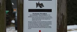 Ein Schild hängt am Grundstückstor vor dem Haus in Cottbus, in dem sogenannte Reichsbürger wohnen. Bei einer Razzia gegen die Reichsbürger wurden in der Stadt verschiedene Räumlichkeiten durchsucht.