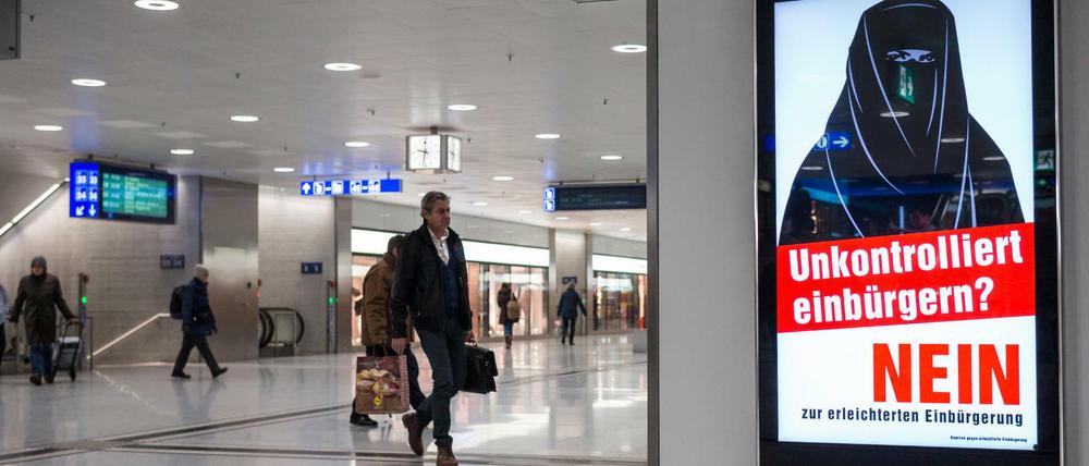 Im Hauptbahnhof von Zürich hängen Plakate gegen die erleichterte Einbürgerung junger Ausländer.