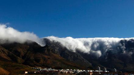 Wolken türmen sich über der Bergkette mit dem berühmten Tafelberg über den Dächern der südafrikanischen Metropole Kapstadt. 
