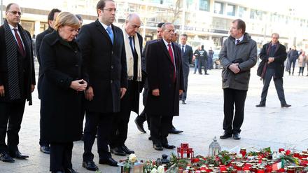 Bundeskanzlerin Angela Merkel (2.v.l, CDU) gedenkt mit Tunesiens Ministerpräsident Youssef Chahed (3.v.l) am Dienstag am Breitscheidplatz der Opfer, die bei einem islamistischen Anschlag auf den Weihnachtsmarkt am 19. Dezember 2016 gestorben sind oder verletzt wurden.