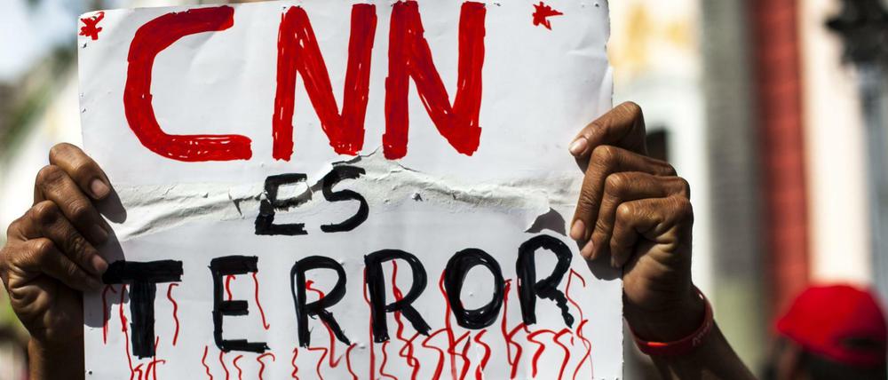Ein Demonstrant in Venezuela hält ein Schild mit der Aufschrift "CNN ist Terror".
