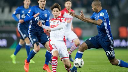 Unentschieden? Kölns Yuya Osako (M) und Schalkes Benjamin Stambouli (l) und Naldo kämpfen um den Ball. 