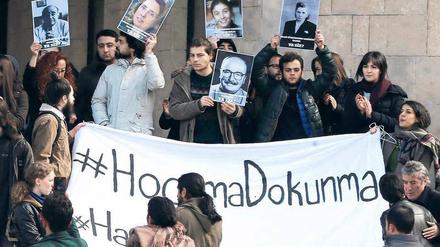 Studenten und Professoren halten vor einem Universitätsgebäude Transparente mit Parolen in türkischer Sprache hoch.