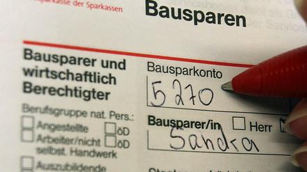 Eine Frau füllt einen Antrag für einen Bausparvertrag aus. 