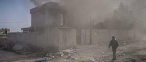Ein Mann geht in Mossul, Irak, in der Nähe des Flughafens an einem in Brand gesetzten Haus vorbei.
