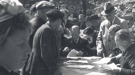 Entnazifizierung. Menschenschlangen an einem Polizeirevier bei der Abgabe der Entnazifizierungsbögen 