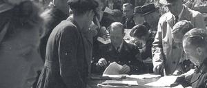 Entnazifizierung. Menschenschlangen an einem Polizeirevier bei der Abgabe der Entnazifizierungsbögen