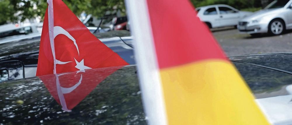 Deutschlandfahne und türkische Flagge an einem Auto in Berlin.