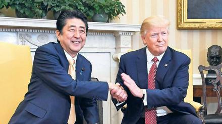 Hand drauf. Donald Trump ergreift die Hand, hält sie fest, tätschelt – und bringt so den japanischen Premier Shinzo Abe in Verlegenheit.