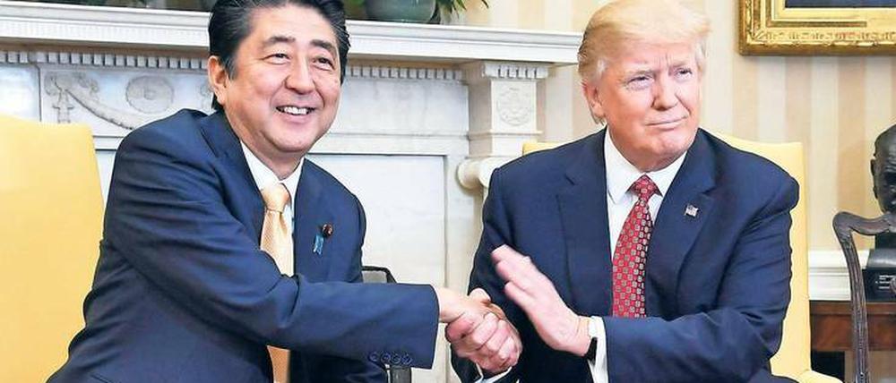 Hand drauf. Donald Trump ergreift die Hand, hält sie fest, tätschelt – und bringt so den japanischen Premier Shinzo Abe in Verlegenheit.