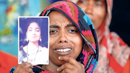 In den Trümmern des Rana Plaza trauert eine Frau um eine Angehörige.