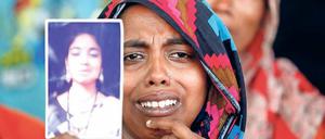 In den Trümmern des Rana Plaza trauert eine Frau um eine Angehörige.