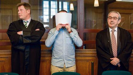 Der wegen Mordes angeklagte Hamdi H. steht am 27. Februar 2017 neben seinen Verteidigern in einem Verhandlungssaal des Landgerichts Berlin. 