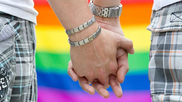 Zwei schwule Männer halten sich an den Händen (Archivbild).