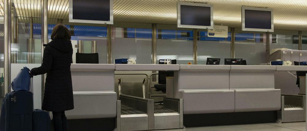 Schon beim Warnstreik verwaist: Eine Flugreisende steht in Berlin-Tegel an einem leeren Check-in-Schalter.