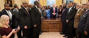Kellyanne Conway, Beraterin von US-Präsident Donald Trump, beschäftigt sich am Montag mit ihrem Handy, während Donald Trump mit Vertretern amerikanischer Universitäten spricht. Das Foto wurde im Oval Office aufgenommen.