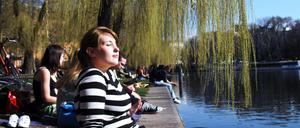 Junge Menschen genießen das schöne Wetter in Berlin, hier am Landwehrkanal in Berlin-Kreuzberg.