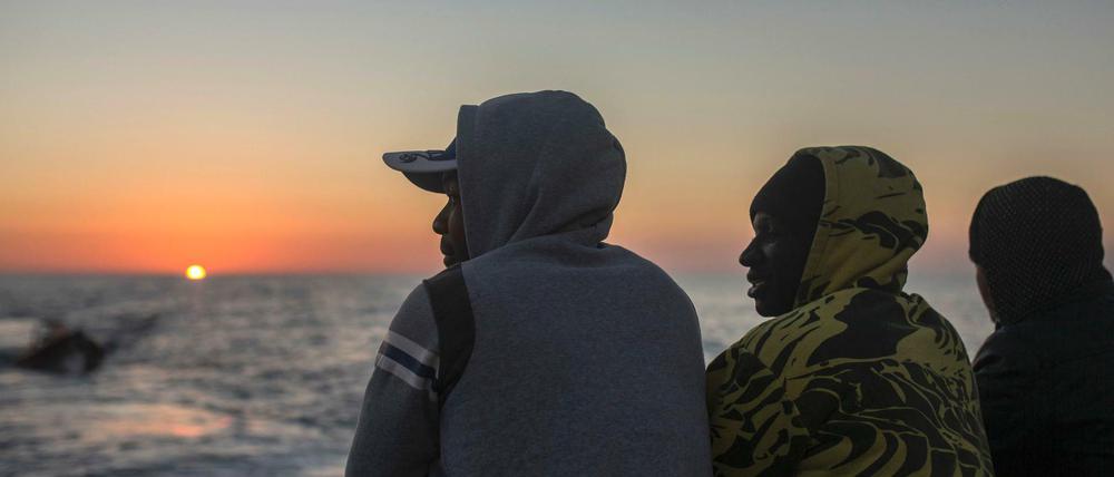 Bootsflüchtlingen aus Afrika und Asien schauen am an Bord des Rettungsschiffs Golfo Azzurro, der spansichen NGO Proactiva Open Arms aufs Meer.