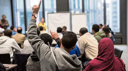 Flüchtlinge sitzen in Frankfurt am Main beim Deutschunterricht. 