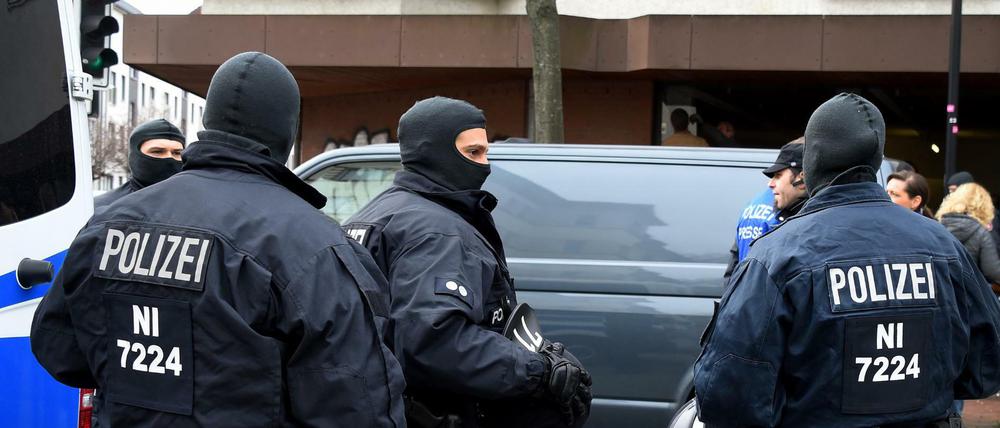 Polizeibeamte und Polizeifahrzeuge stehen am Dienstag vor der Moschee des Deutschsprachigen Islamkreises Hildesheim e.V. (DIK) in Hildesheim (Niedersachsen).