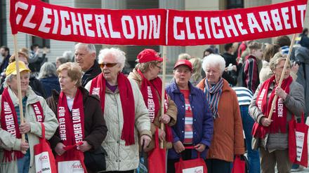 Demonstrantinnen und Demonstranten fordern am 21.03.2014 am Brandenburger Tor in Berlin die gleiche Bezahlung von Frauen und Männern.