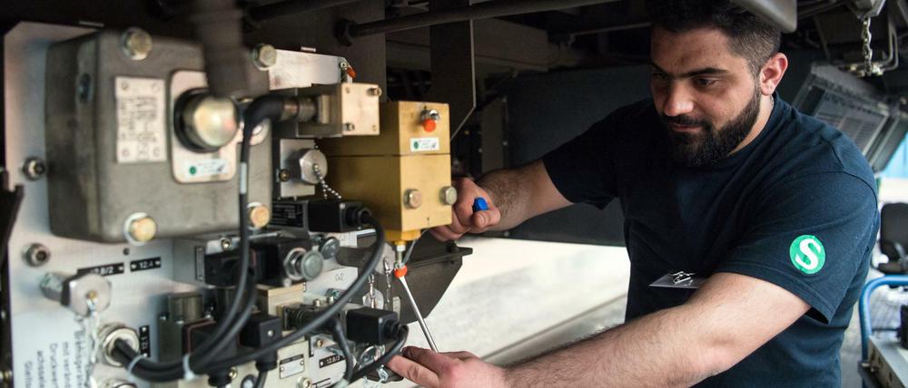 Der Syrer Saadi aus der Qualifizierungsklasse für junge Flüchtlinge der Deutschen Bahn arbeitet in Berlin im Werk Schöneweide der S-Bahn an der Elektronik-Komponente einer Bremsgeräteeinheit. 