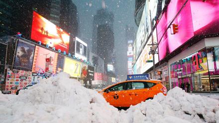 Ein Taxifahrer passiert auf dem Times Square in New York einen Schneehaufen. 