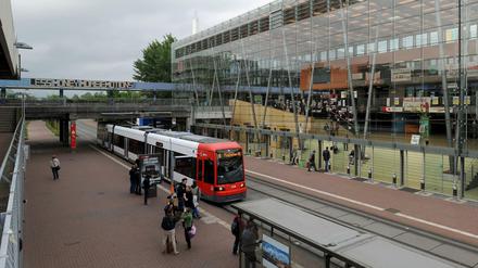 Eine Straßenbahn fährt vor einem Universitätsgebäude fest.